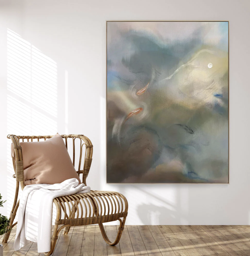 A framed abstract painting and a rattan chair.