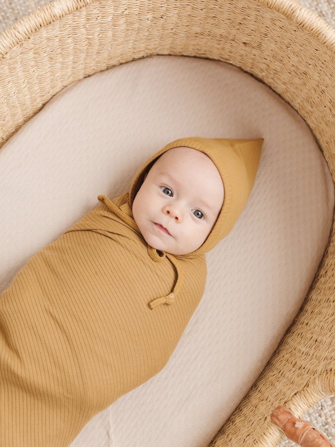Baby sleeping in a Quincy and Mae swaddle blanket.