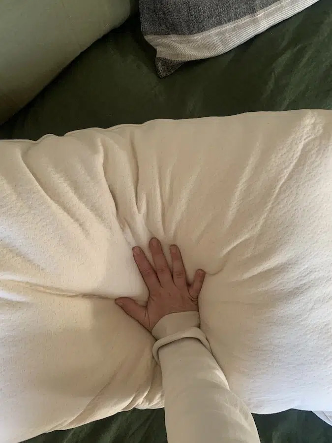 A hand pressing into a Birch pillow.