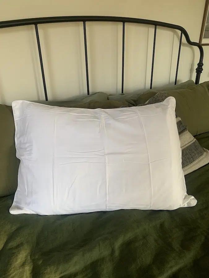 A Boll & Branch organic pillow on a bed.