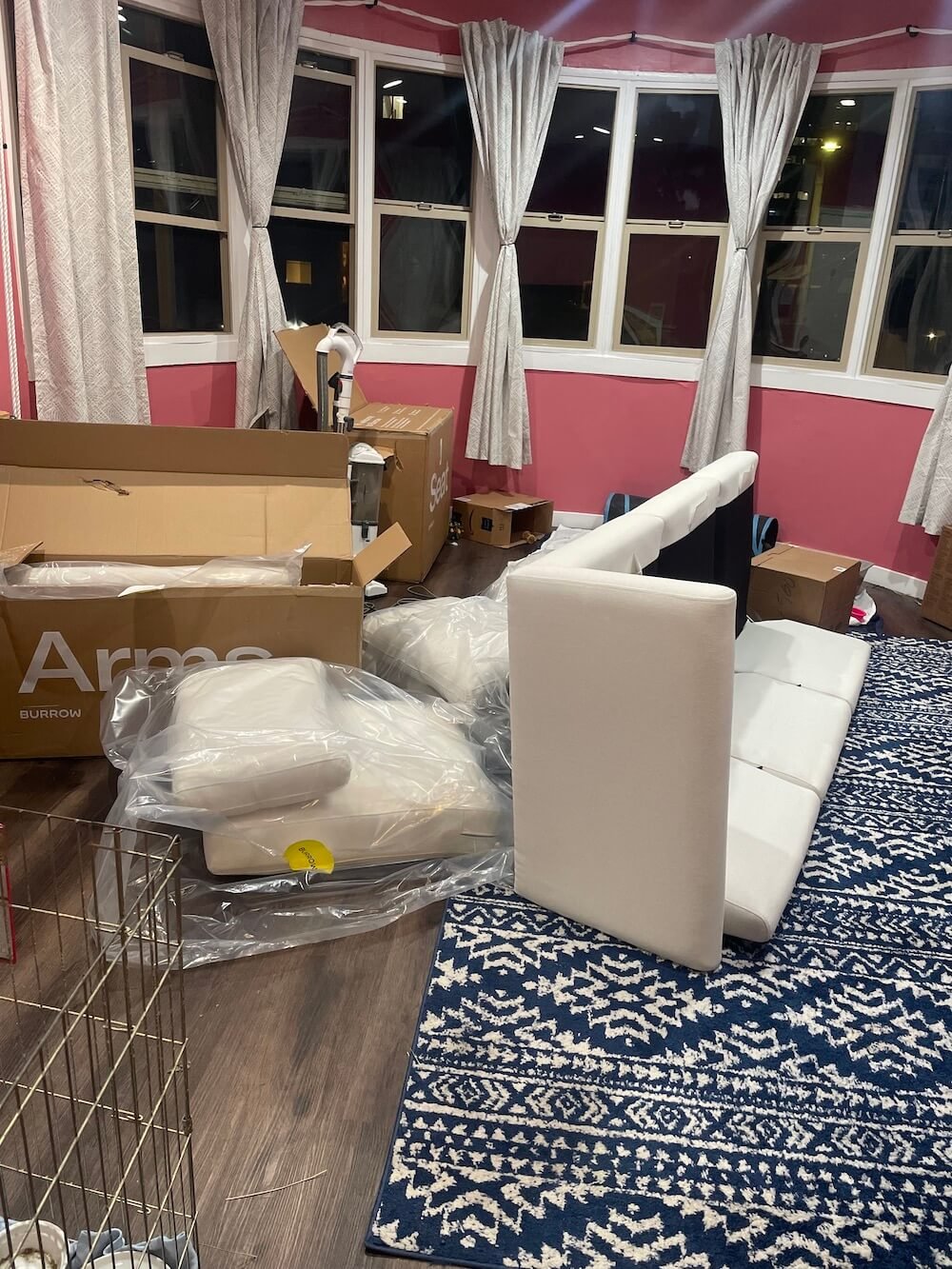 A Burrow couch being assembled in a pink living room.