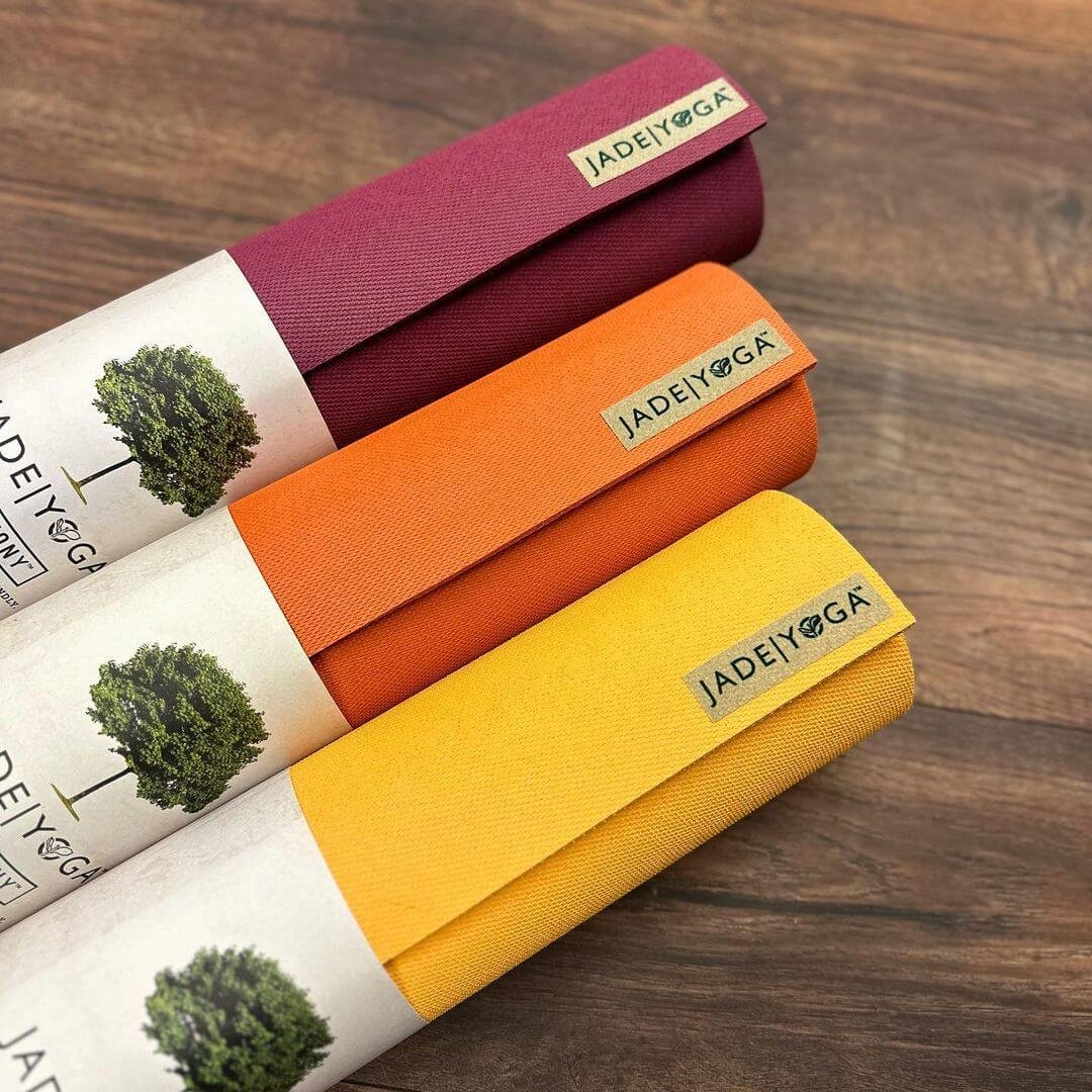 Three rolled up Jade Yoga mats. 