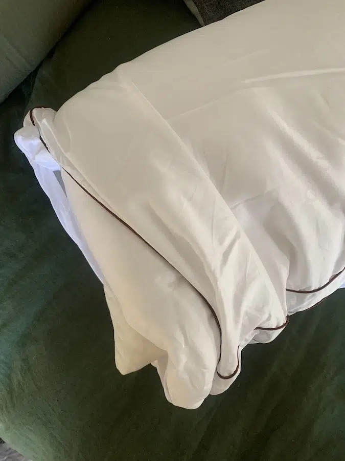 A Saatva organic pillow partially in its case.