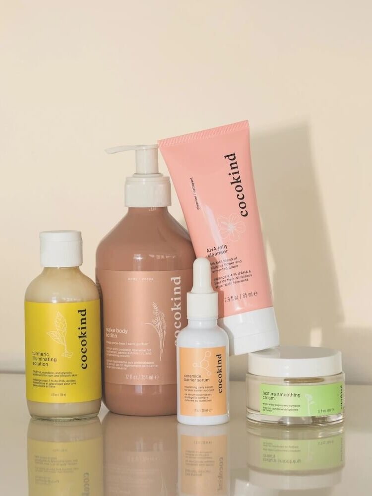 A collection of Cocokind skincare products, including lotion, toner, serum, and cream, arranged on a surface.
