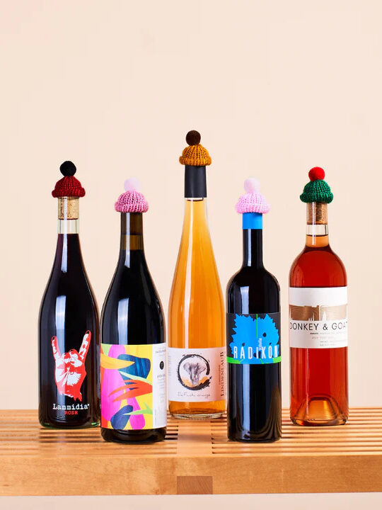 Five bottles wearing little knit caps. 