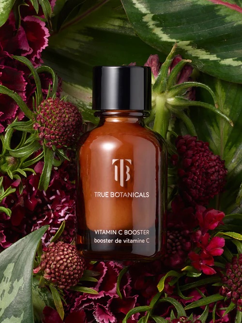 A bottle of the product lying in a background of foliage.