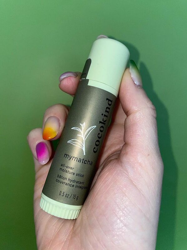A hand holding cocokind's mymatcha all over moisture stick.