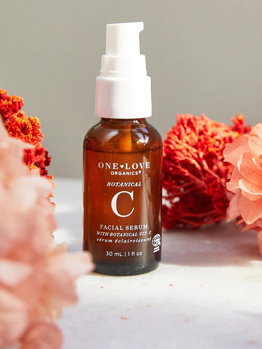 The bottle sitting on a table with flowers and coral.