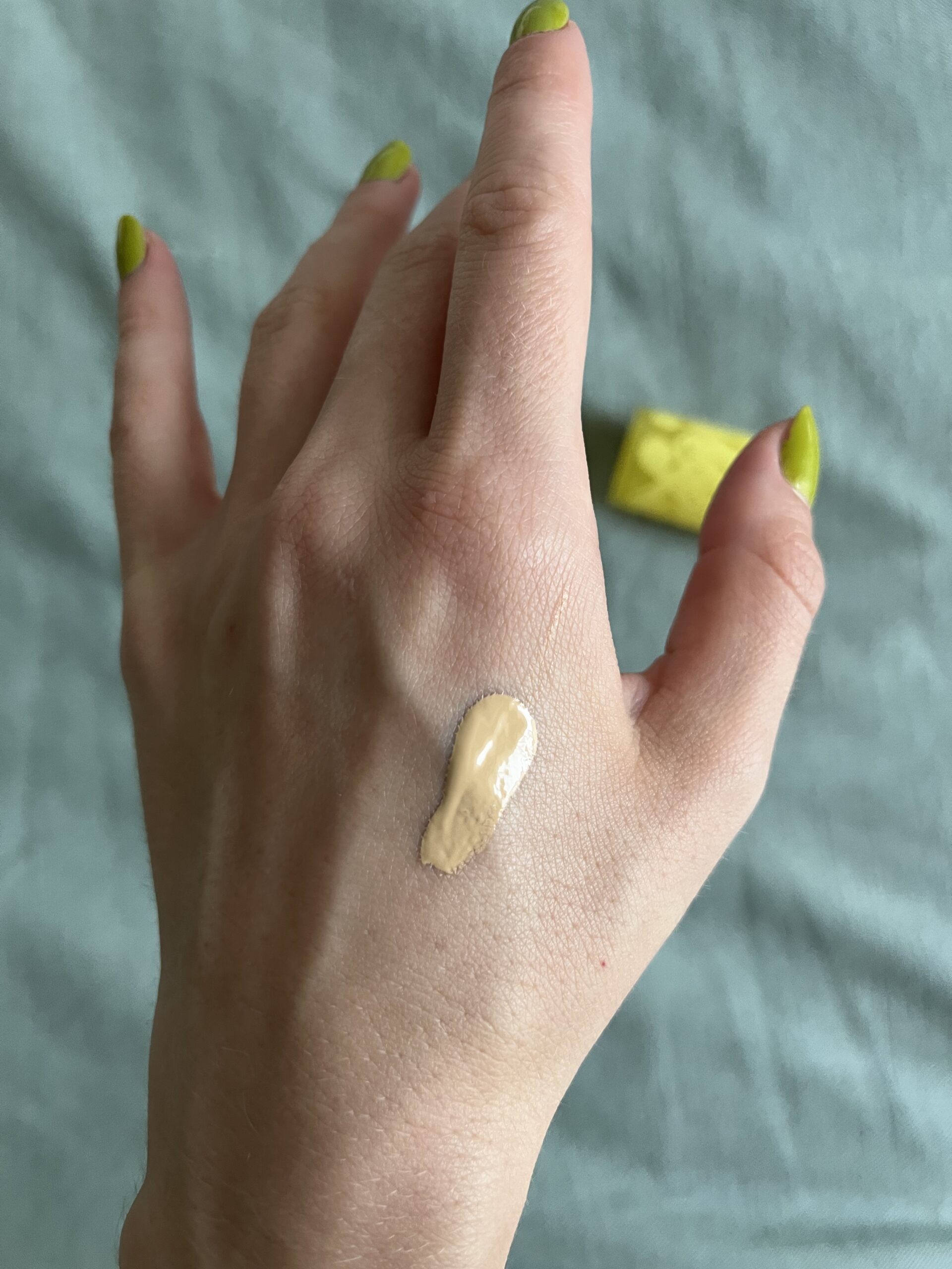 A sample of Kosas foundation on the back of a hand.