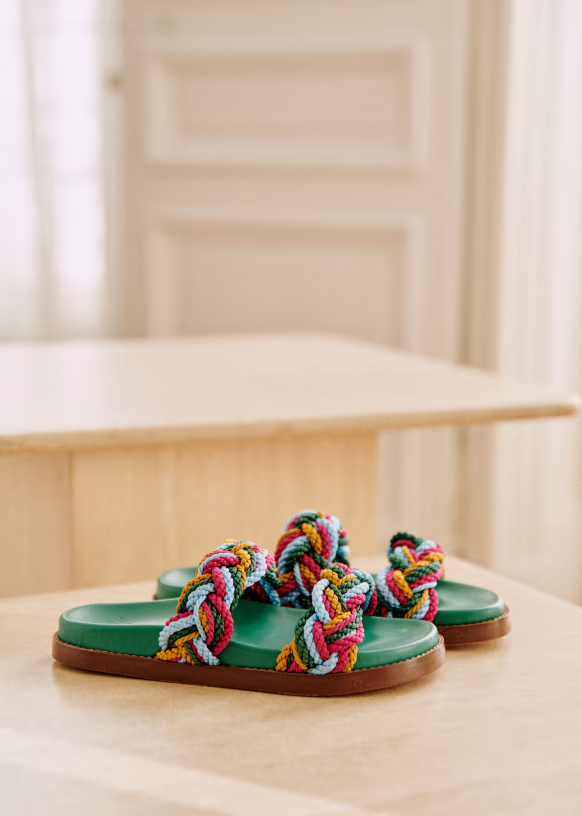 A pair of green-footbed and multicolored braided strapped mule sandals.