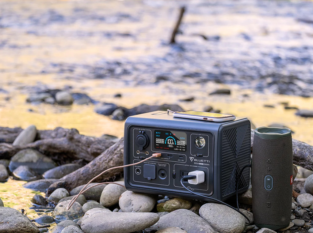 A Bluetti solar generator sitting outside on some rocks. 