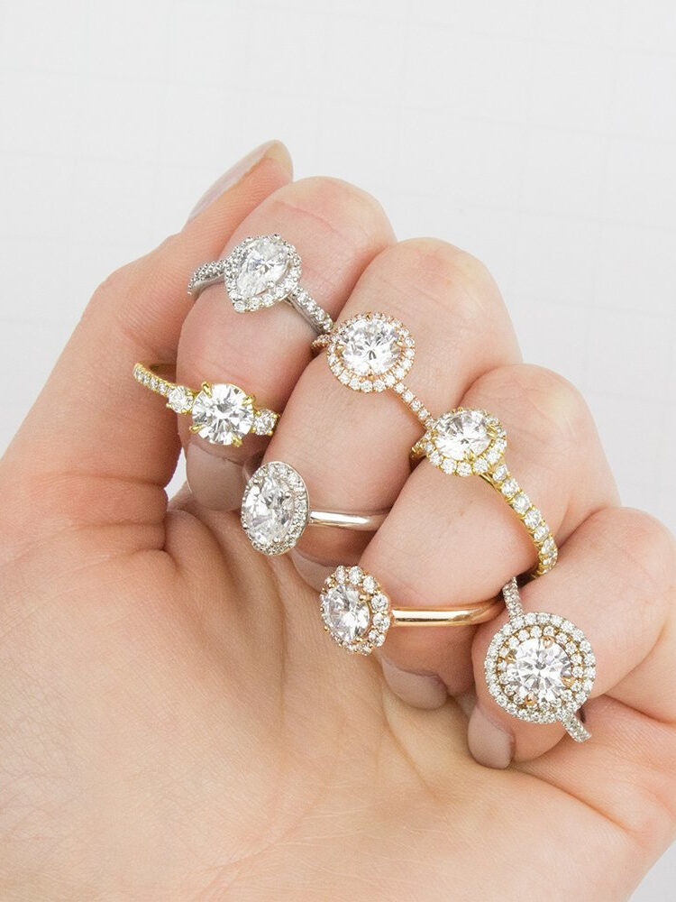 Close up of many moissanite rings on a model's hand from Brilliant Earth