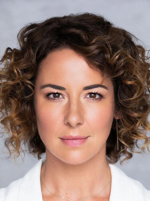 A model with curly hair displaying the results of EVOLVh's curly hair line.