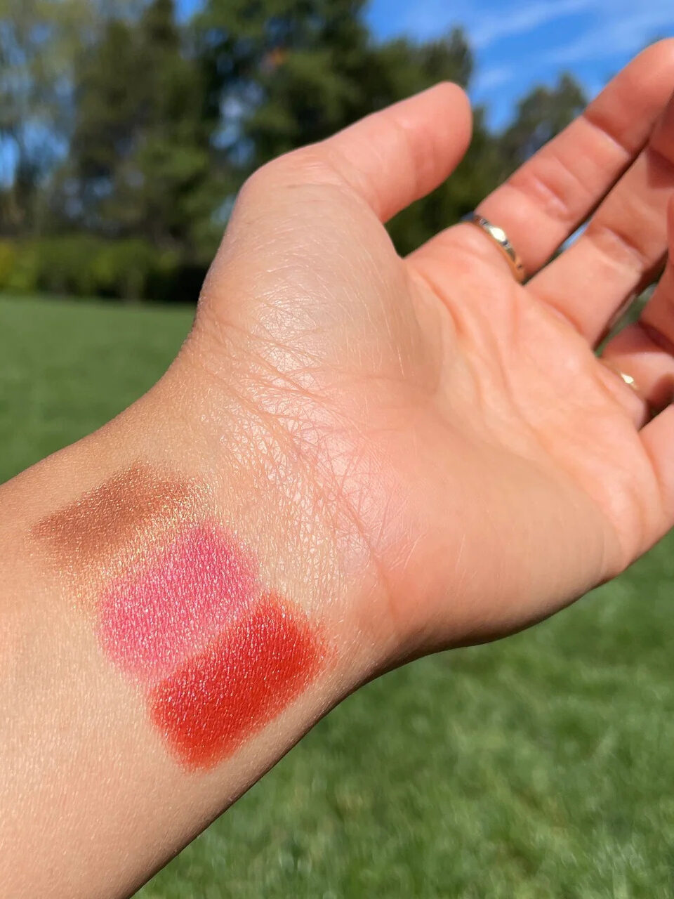 A hand swatch of three Axiology multi-use crayons.