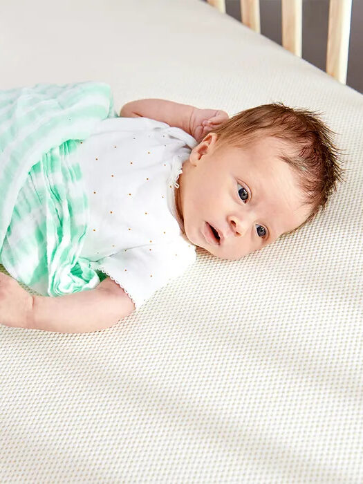 Baby laying in a Avocado crib mattress