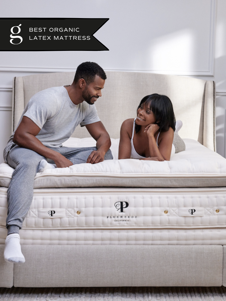 A couple smiles at each other on their Plushbeds natural latex mattress.
