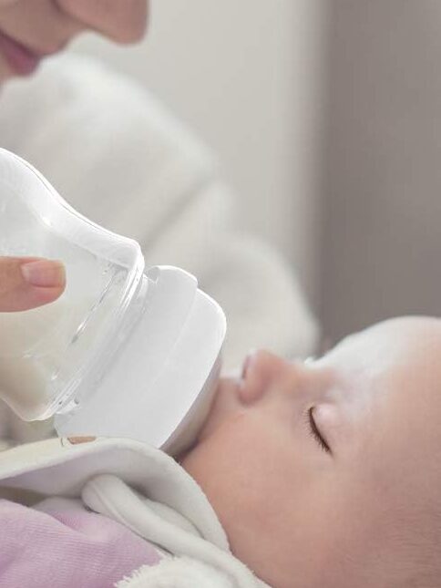 A baby drinking milk from a bottle.