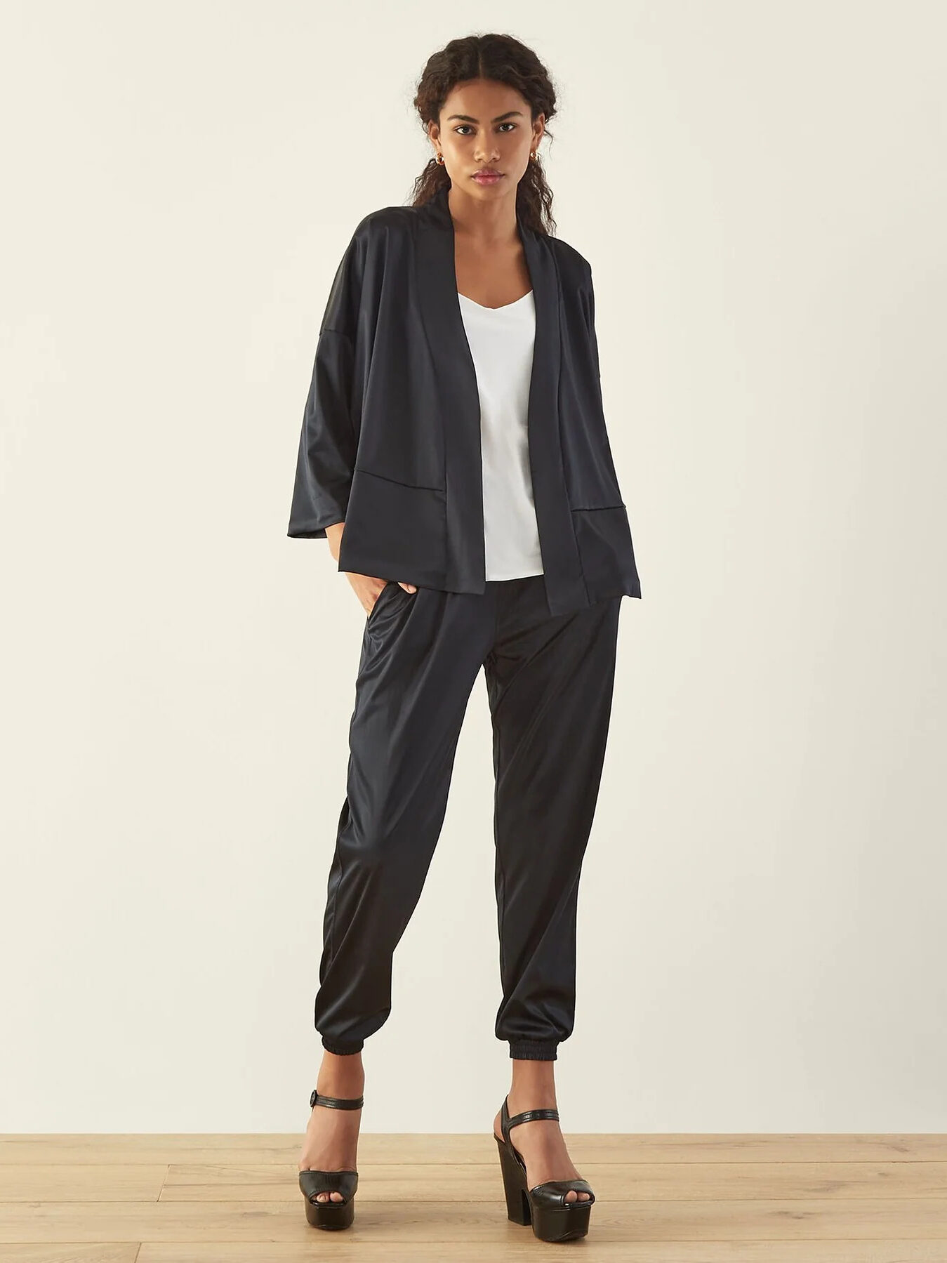 A model wearing a black kimono and black joggers from ADAY.