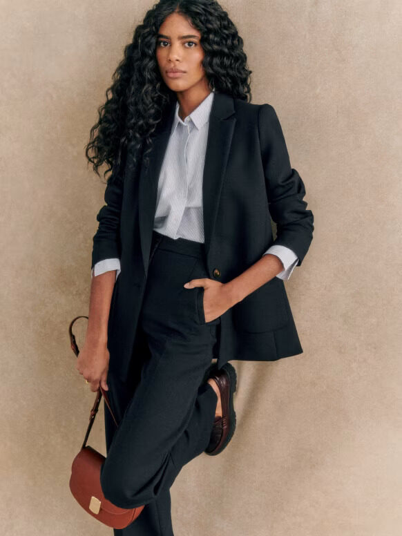 A model wearing a black pantsuit from Sezane.