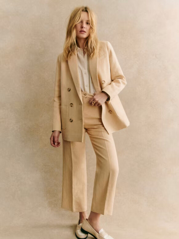 A model wearing a beige pantsuit from Sezane.