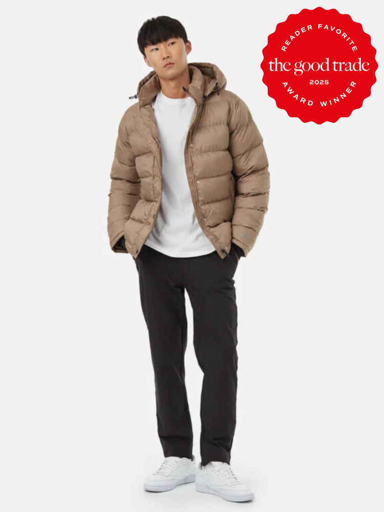 Person wearing a tan puffer jacket, white shirt, black pants, and white sneakers. A red badge on the image reads "Reader Favorite, the good trade, 2025, Award Winner.