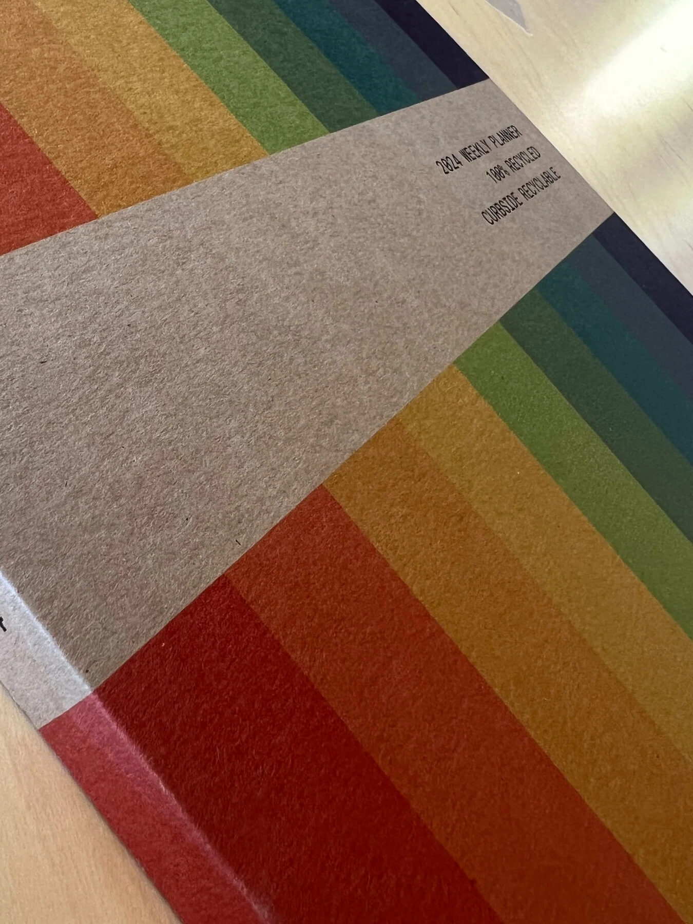 Close up shot of the front of Wisdom Supply Co.'s rainbow 2024 planner.