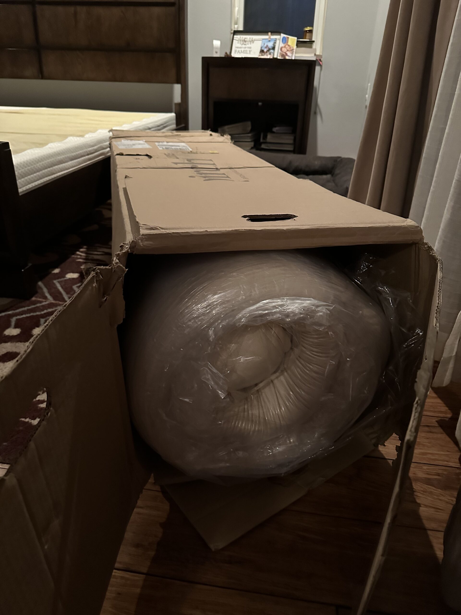 A Birch Luxe mattress delivery box, opened, showing a rolled up mattress inside. 