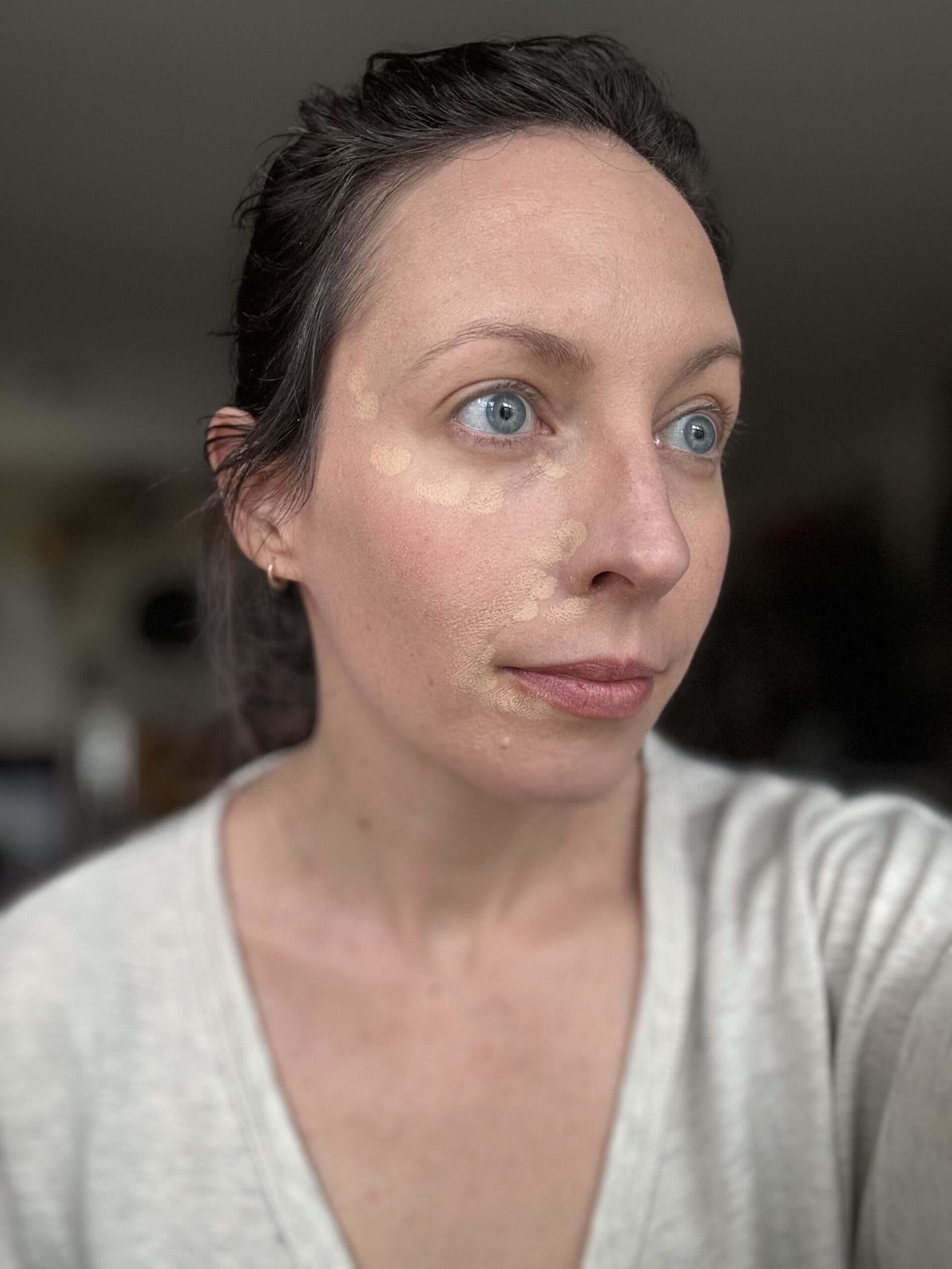 Woman with foundation dots on her face before blending.