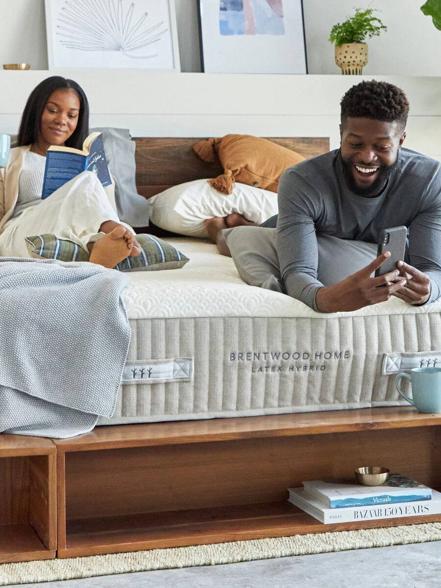 A couple relax on a Brentwood Home latex hybrid mattress together.