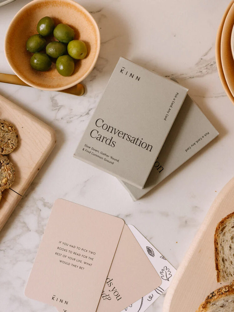 A table with bread, olives, and cards on it.