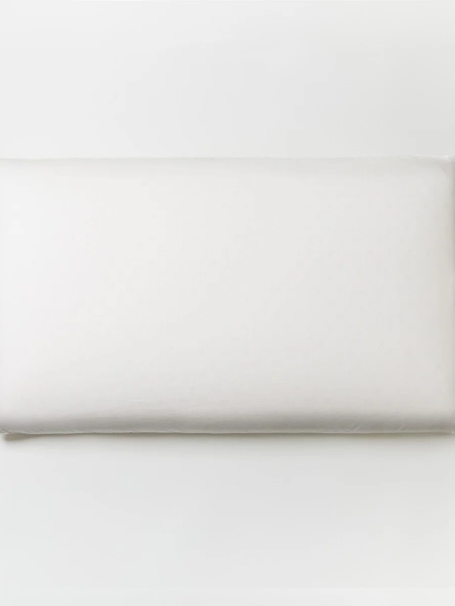 A rectangular white pillow against a plain white background.