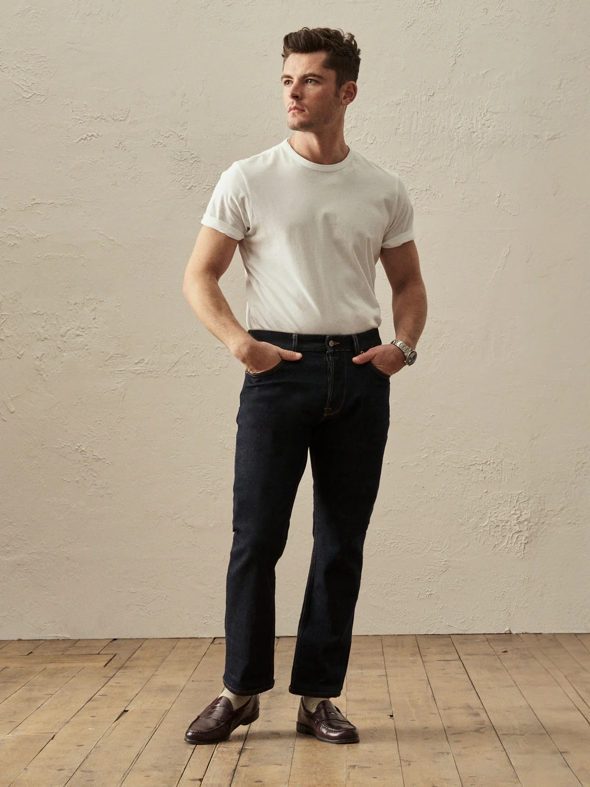 A model wearing Buck Mason dark wash jeans.