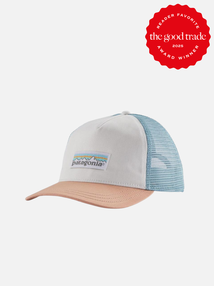 White and blue mesh trucker hat with a brown brim and "Patagonia" logo. Awarded "The Good Trade Reader Favorite 2025" badge in red.
