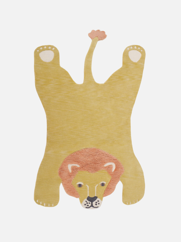 A yellow and orange lion-shaped rug with a cartoon face, outstretched legs, and tail, displayed on a white background.