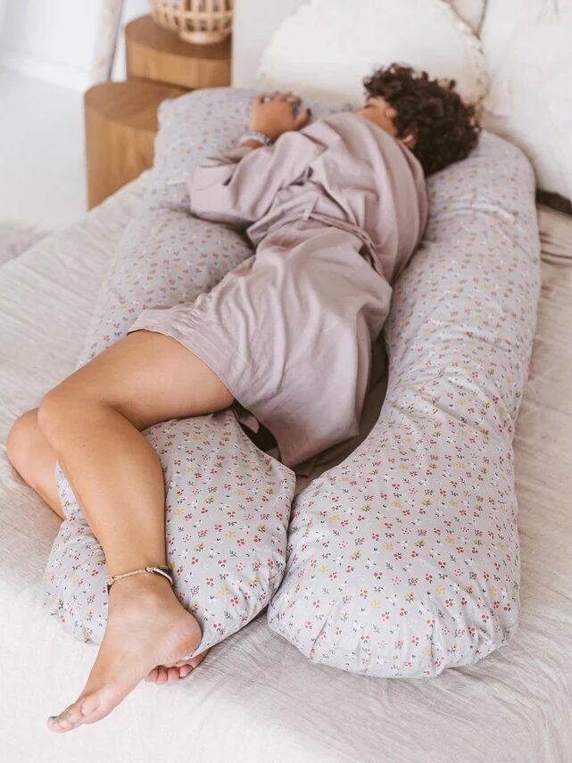 A model sleeping in a MINICAMP body pillow.