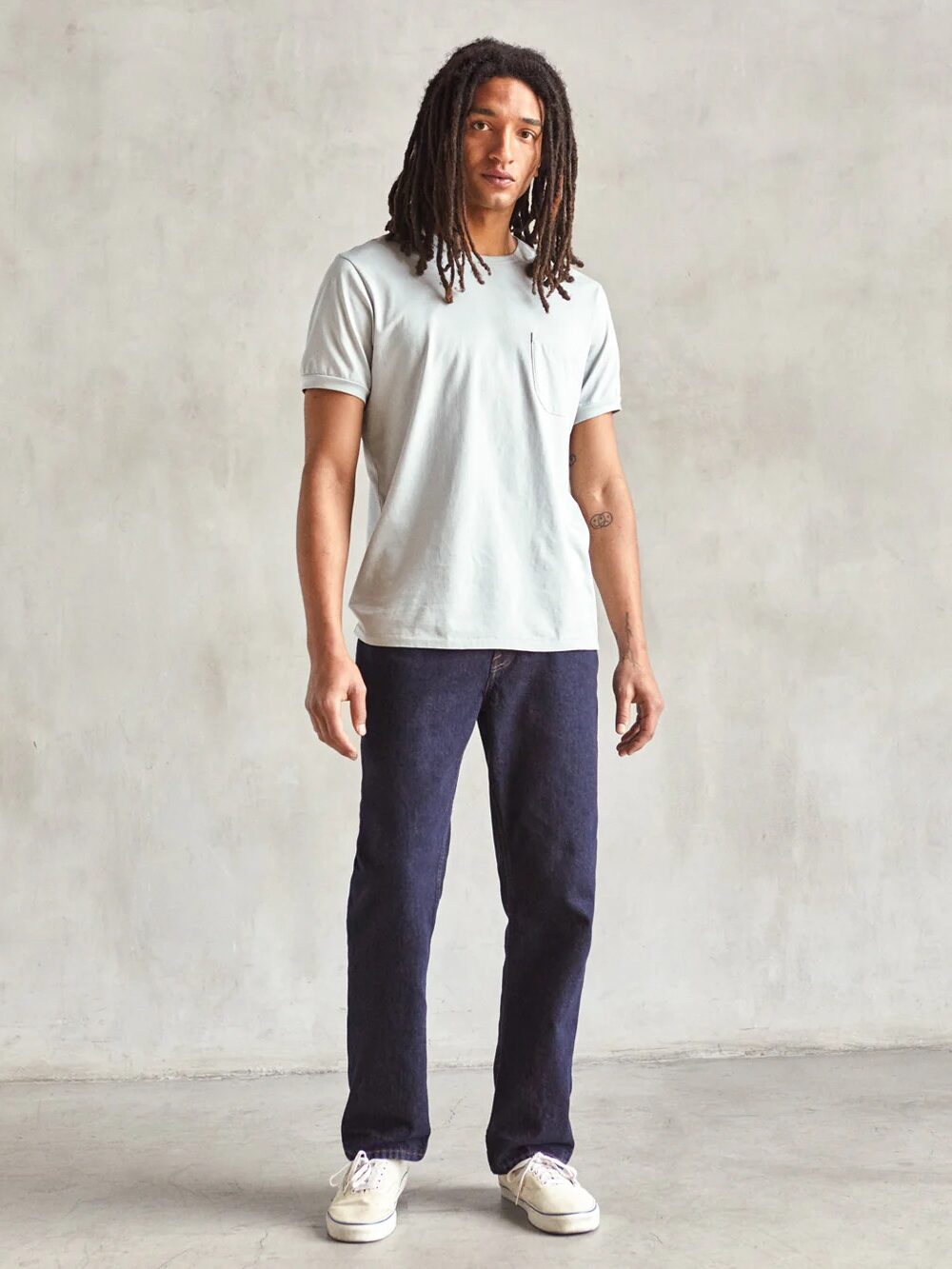 A model wearing darkwash Outerknown jeans.