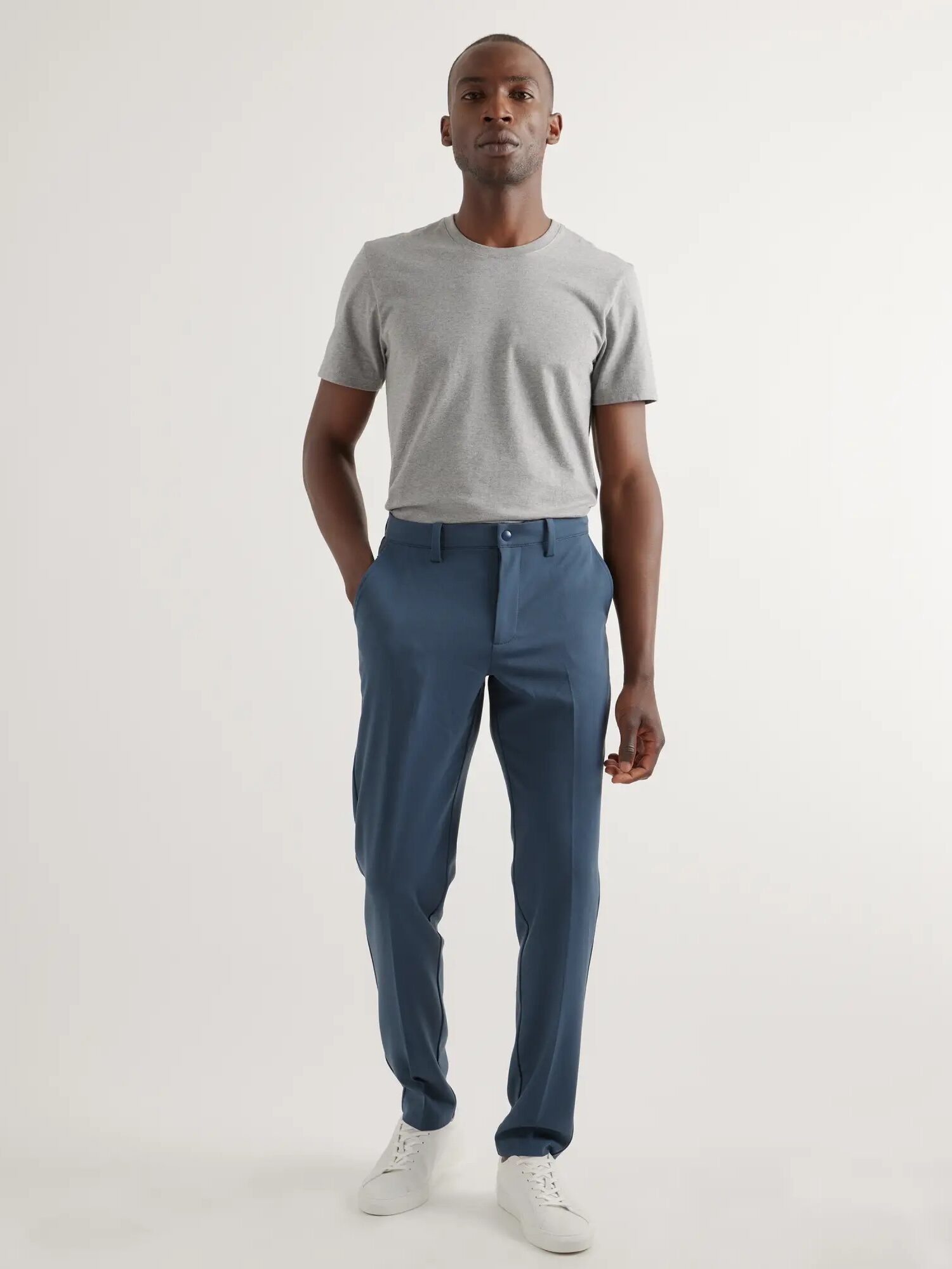 A model wearing blue chino pants from Quince.