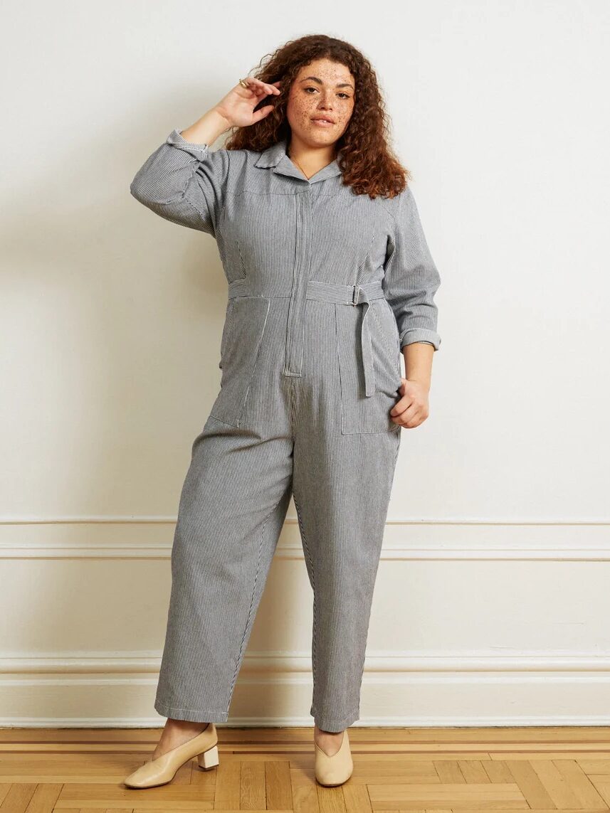 A plus size model wearing a grey pinstripe jumpsuit from Loup.
