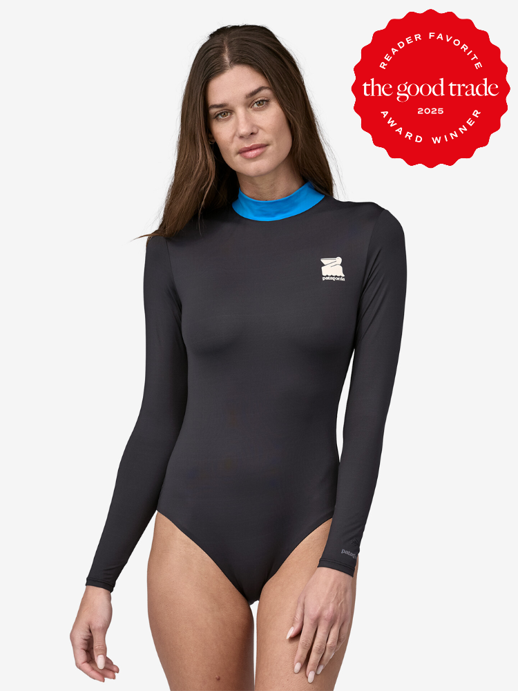 A person wearing a long-sleeve black bodysuit with a blue collar. Award badge for "The Good Trade" 2025 is displayed in the top right corner.