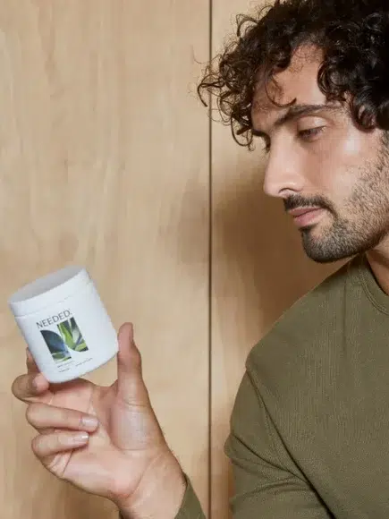 A model holding Needed's men's Sperm+ support. 