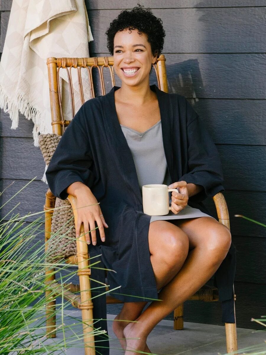 A model wearing a black Coyuchi robe. 