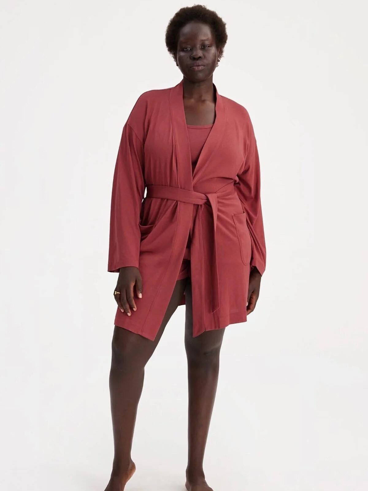 A model wearing a dark blush robe from Girlfriend Collective. 