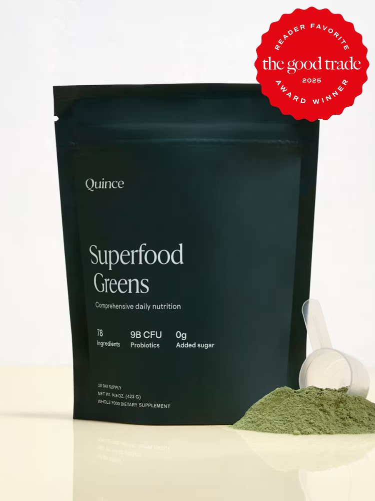 A pouch of Quince Superfood Greens powder with a scoop and some powder beside it; a red award badge says "Reader Favorite, The Good Trade, 2025 Award Winner.
