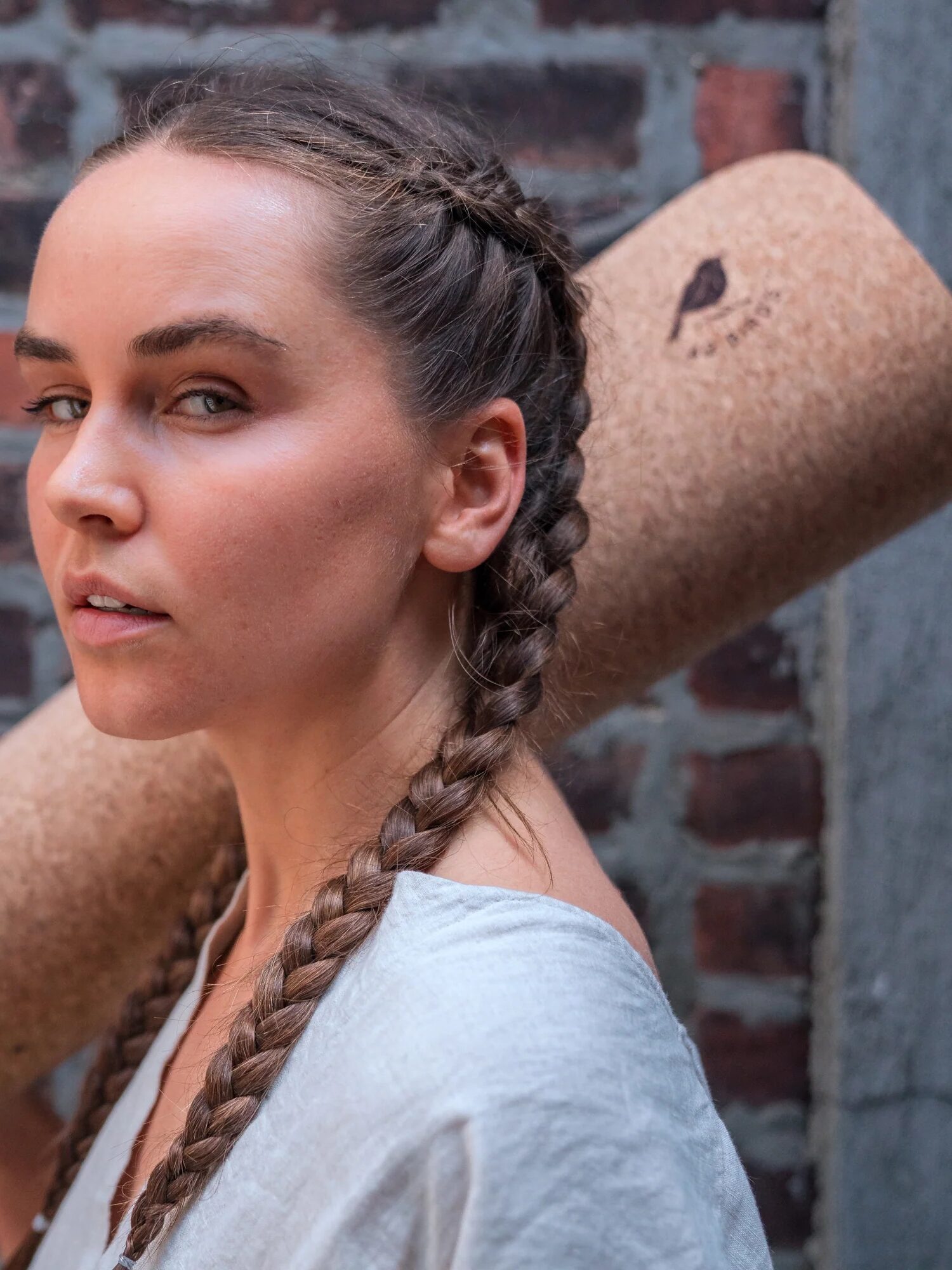 A model holding a 42 Birds yoga mat over their shoulder.
