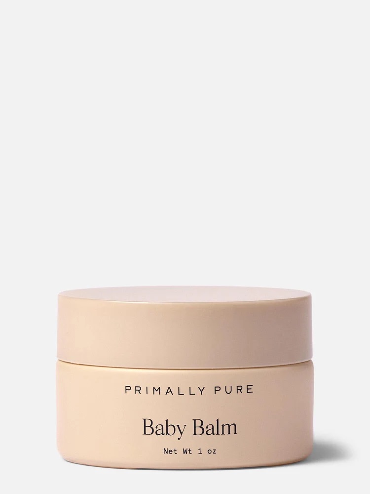 A small beige jar labeled "Primally Pure Baby Balm" with a net weight of 1 oz sits against a plain background.