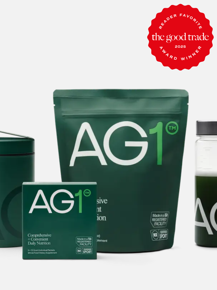 Green packaging of AG1 nutritional product with text highlighting its comprehensive daily nutrition. A red badge in the corner states "Reader Favorite" by The Good Trade 2023 Award Winner.