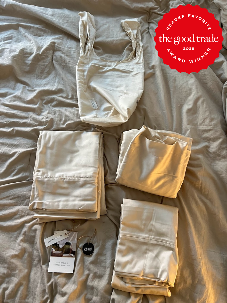A set of beige sheets and pillowcases are neatly arranged on a bed with a red "The Good Trade Reader Favorite Award Winner 2025" badge in the top right corner.