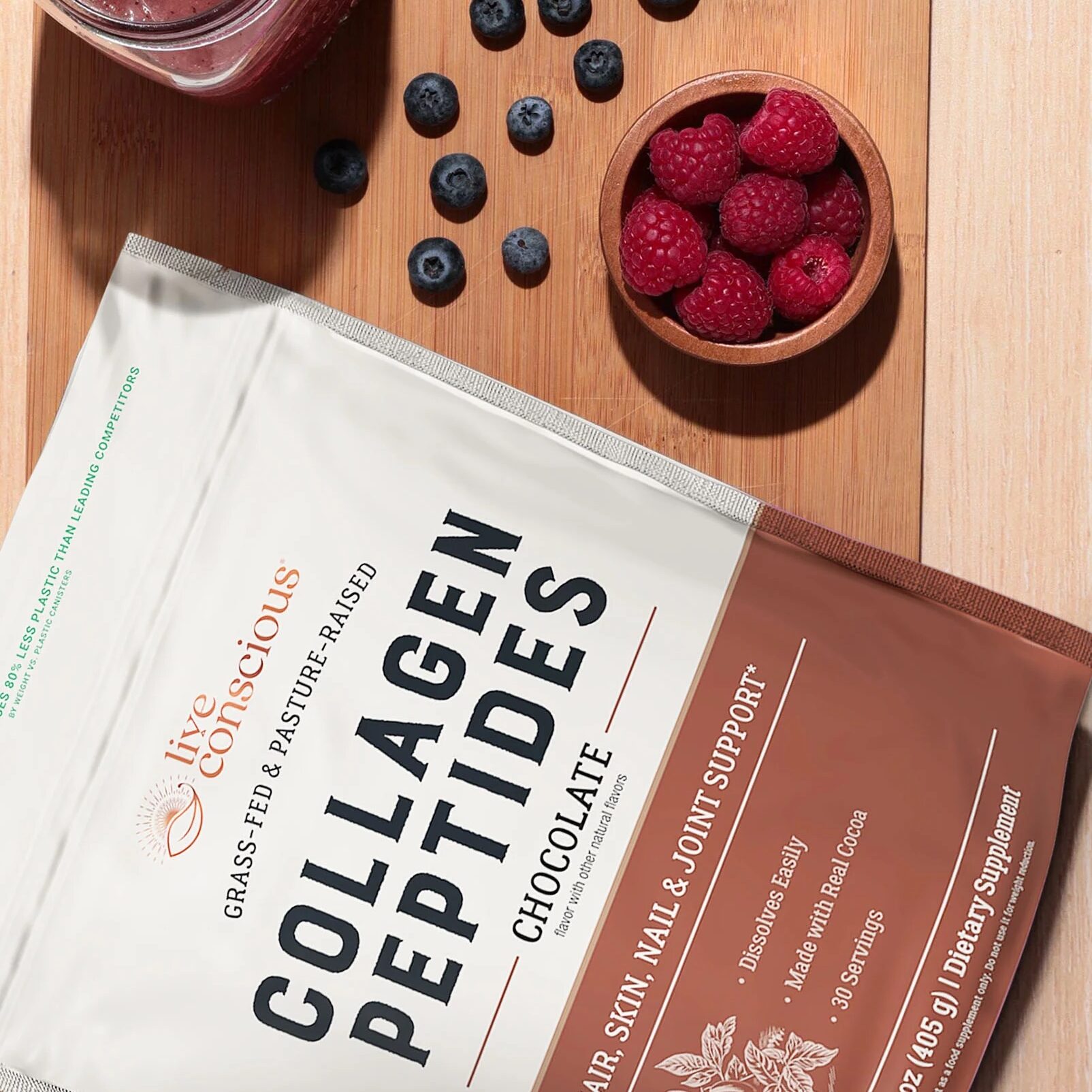 Collagen peptides package with chocolate flavor, a smoothie, chocolate pieces, and raspberries on a wooden surface. Text highlights benefits for skin, hair, and nails.