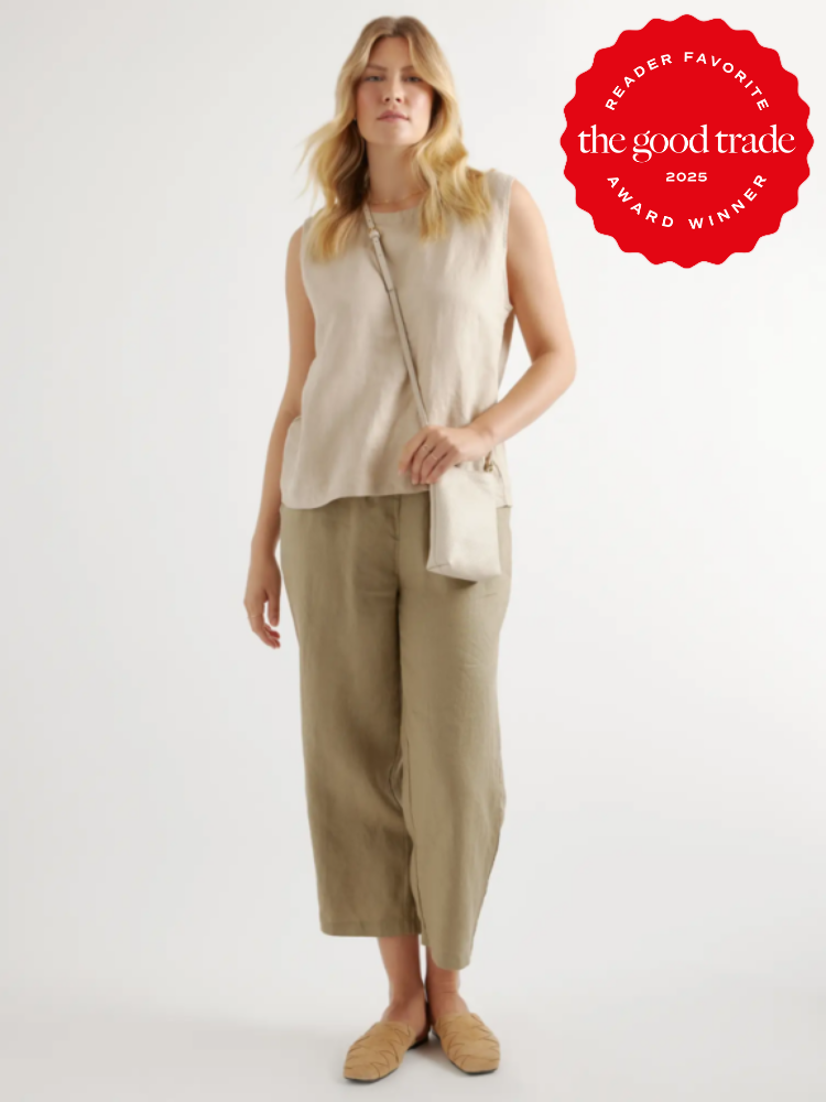 Person wearing a beige sleeveless top, olive green pants, and tan shoes, holding a small white bag. Red circular badge on the top right reads "Reader Favorite, The Good Trade, Award Winner 2023.