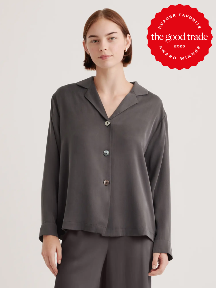 Woman wearing a loose, dark gray button-up shirt. Red badge on upper right says "The Good Trade Reader Favorite 2025 Award Winner.